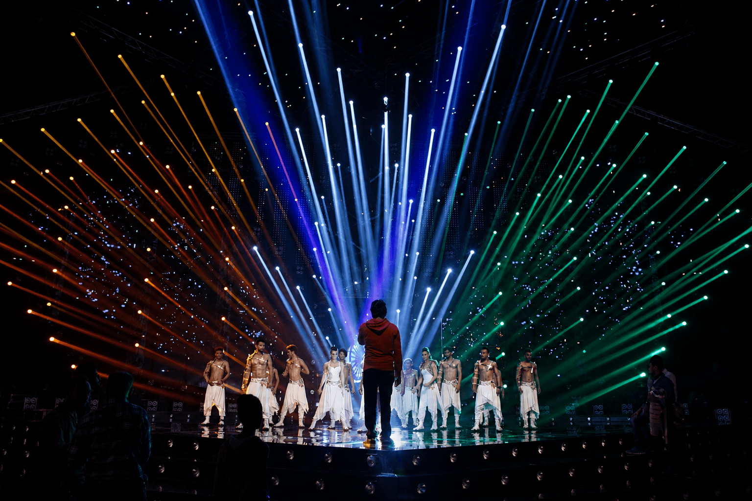 Stage direction — performers under tricolor light beams